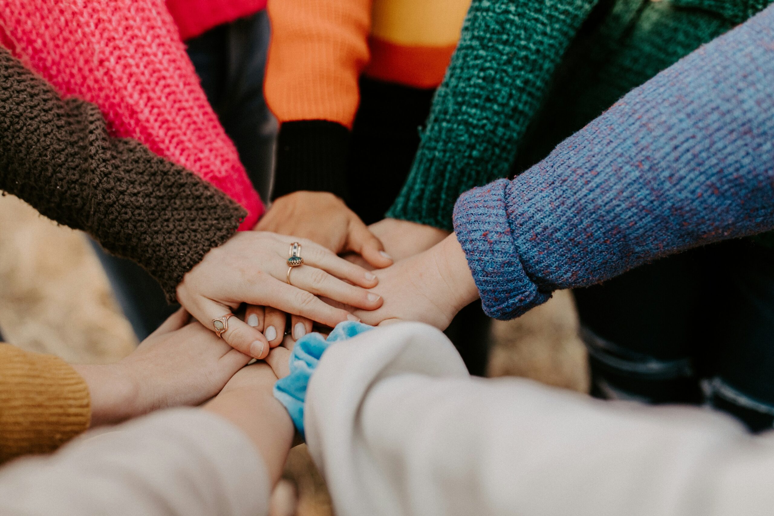 A diverse group of hands touching,
